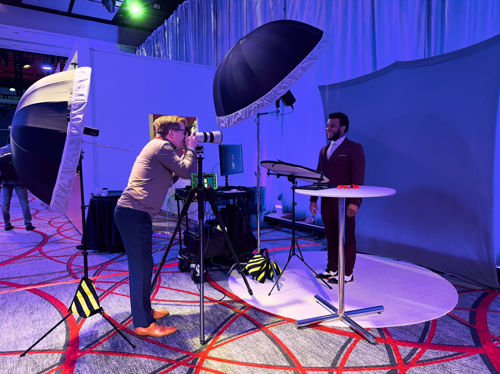 Photographer shooting attendees at an event headshot booth